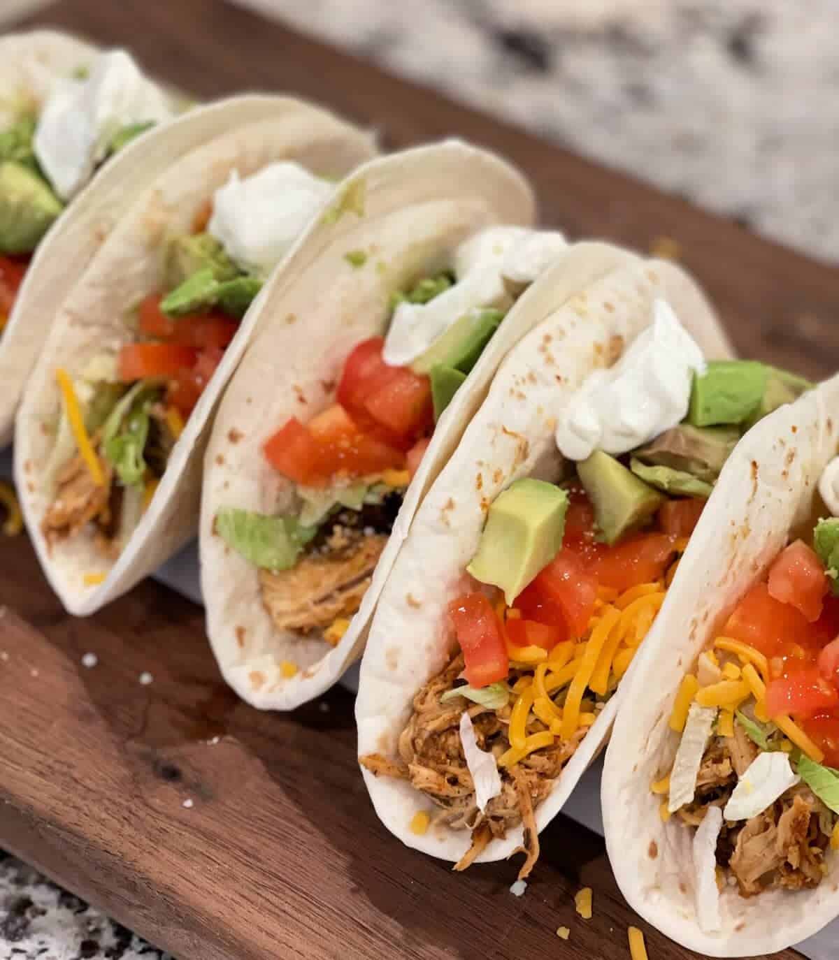 Chicken taco with fresh vegetables and cheese on soft tortillas.